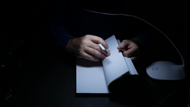 Businessman in Office Room Late in Night Read and Write in a Contract Using Pen
