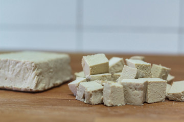 Tofu piece and diced tofu on wooden board