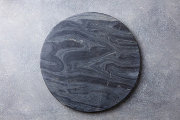 Black marble texture board on grey background. Top view. Copy space.