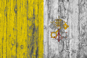 Flag of Vatican City - Holy See painted on worn out wooden texture background.