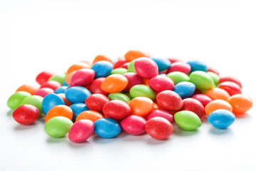 Rainbow-colored candies, multicolored close-up, texture and repetition of dragee