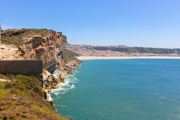 Amazing view of North Beach (Praia do Norte) rocky cliff coastline of Atlantic ocean Nazare, Portugal