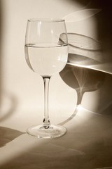 A glass of clean water on a light background with shadows and reflections