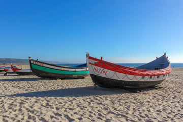Portuguese Traditional colorfull fishing boats  on the beach of Nazare, Portugal