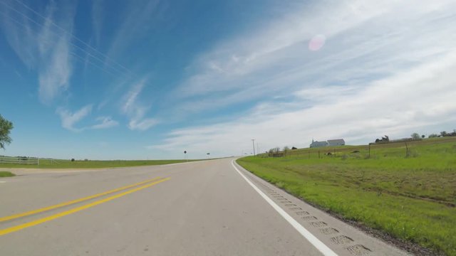 POV. Point of view countryside in the spring. View of beautiful open green areas and a bluebonnet patchs beside the road.