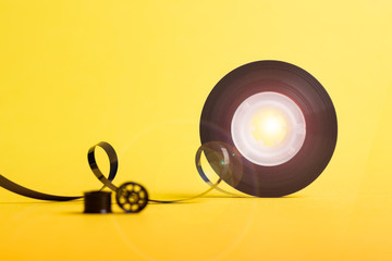 reel music tape and sunlight over yellow background