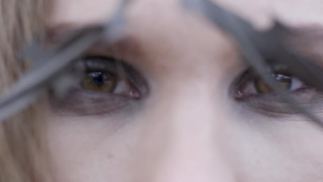 Close-up of a young woman's eyes through barbed wire. Action. Beauty fashion concept