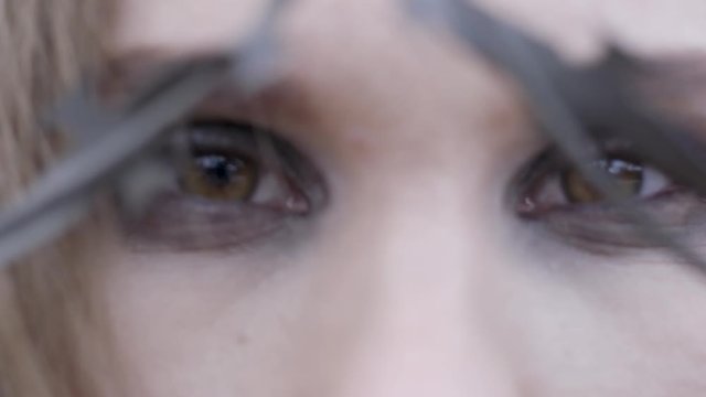 Close-up of a young woman's eyes through barbed wire. Action. Beauty fashion concept