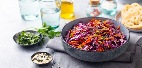 Red cabbage salad. Coleslaw in a bowl. Grey background.
