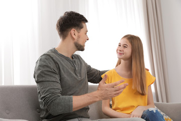 Father talking with his teenager daughter at home