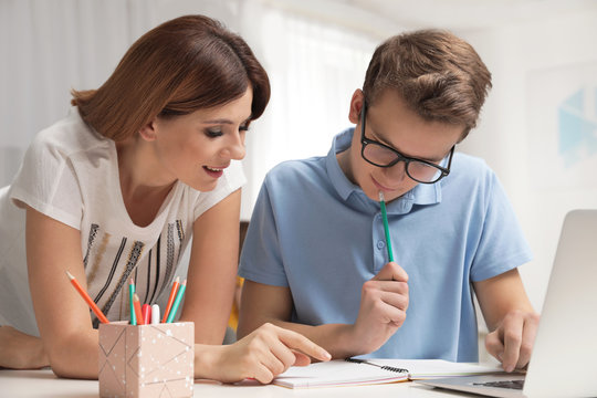 Mother Helping Her Teenager Son With Homework Indoors