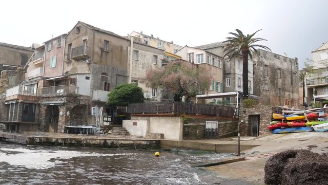 Erbalunga, Cap-Corse, Corsica, France, Europe - april 22 2019: Large waves batter on the harbor of Erbalunga (fishing village). The stormy sea on Torra d'Erbalunga, tower from the 16th century