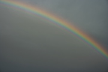 Fototapeta premium Colorful bright rainbow against a dark sky over the countryside in Transylvania, Romania in eastern Europe