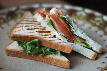 Closeup of sandwich with smoked salmon creamcheese and greens on a beautiful plate