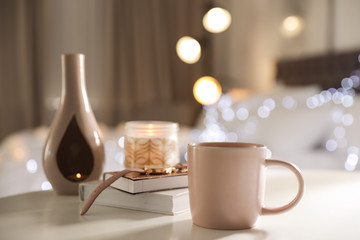 Composition with cup of drink on table against blurred background. Space for text
