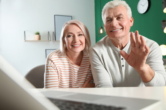 Mature couple using video chat on laptop at home