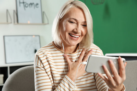 Mature Woman Using Video Chat On Mobile Phone At Home