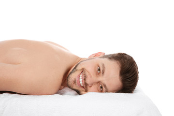 Fototapeta na wymiar Handsome man relaxing on massage table against white background. Spa service