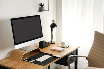 Stylish workplace interior with modern computer on table. Mockup for design