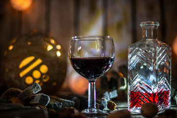 Red wine on a wooden table in front of a wooden background with a creative lighting