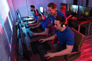 Fototapeta na wymiar Young people playing video games on computers indoors. Esports tournament