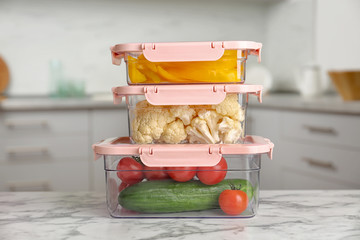 Boxes with fresh raw vegetables on table in kitchen