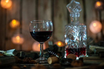 Red wine on a wooden table in front of a wooden background with a creative lighting