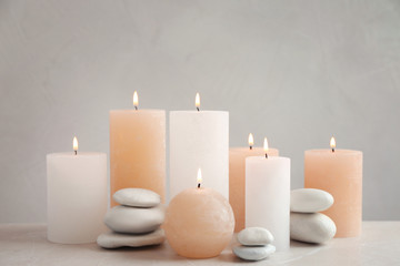 Fototapeta na wymiar Beautiful composition with candles on table against grey background