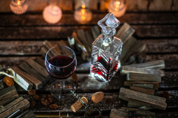 Red wine on a wooden table in front of a wooden background with a creative lighting