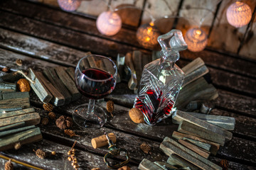 Red wine on a wooden table in front of a wooden background with a creative lighting