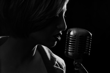 Silhouette of singing woman with retro microphone