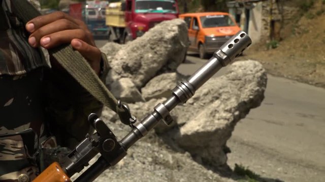 Extreme close up of the barrel of an automatic rifle being held by a guard at the India-Pakistan border