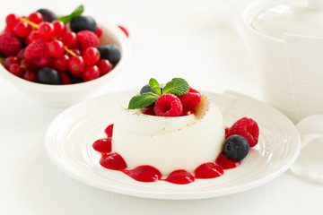 Delicious Italian dessert panna cotta with berries and berry sauce. Valentine's Day.