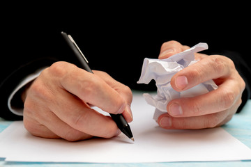 A pen in a man's hand. White sheet of paper. Signing a document.