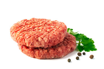 Two raw beef patties with spices on white background
