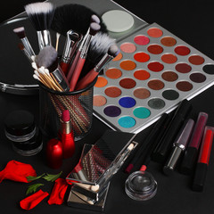 makeup brushes and cosmetics on a black background.