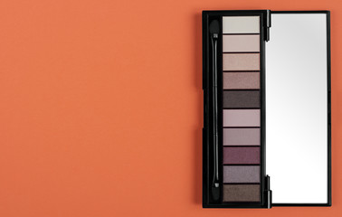 Open Eye shadow palette on orange background