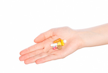 Woman hand holding pills on white