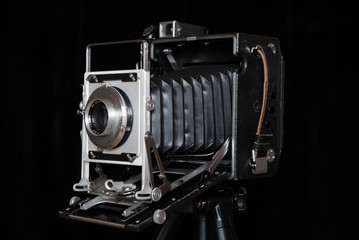 Stary wielkoformatowy aparat fotograficzny na czarnym tle