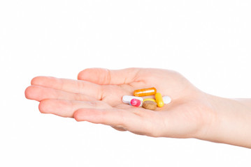 Woman hand holding pills on white