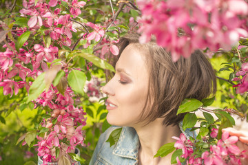 Fototapeta premium gorgeous girl in blossom spring garden enjoying and relaxing