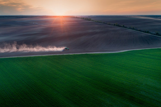 Top view of tractor harrowing in field
