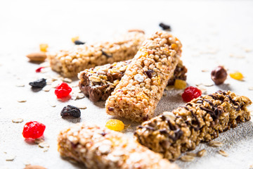 Granola bar with nuts, fruit and berries on white.