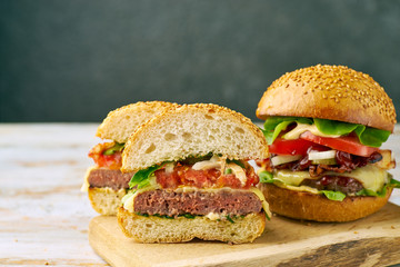 Whole and divided hamburger on old wooden table
