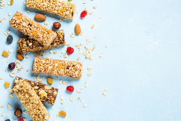 Granola bar with nuts, fruits and berries on blue.