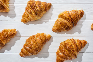 flat lay of tasty and sweet croissants on white surface