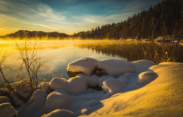 Winter landscape with snow and warm sunset light.