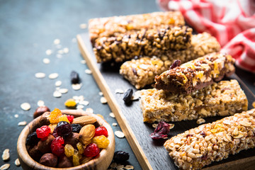 Granola bar with nuts, fruit and berries on black.