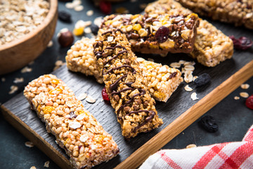 Granola bar with nuts, fruit and berries on black.