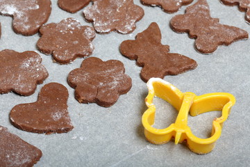 On the baking sheet laid blanks for baking gingerbread. Nearby is a plastic form to give them a shape. Cooking gingerbread.